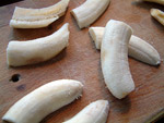 Die Bananen halbieren und dann quer aufschneiden